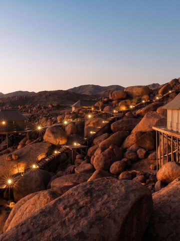 Luxuriöse Zelte auf Felsen in der Wüste bei Sonnenuntergang