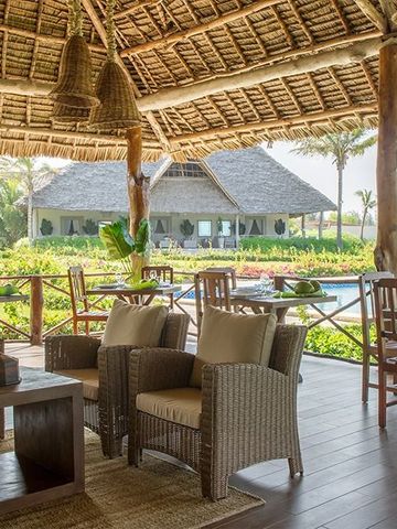 Entspannte Lounge im Freien mit Blick auf üppige Gärten und traditionelle Architektur.