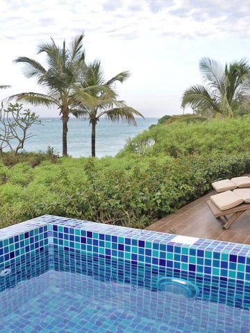 Private Terrasse mit Pool und Meerblick, umgeben von tropischer Vegetation.