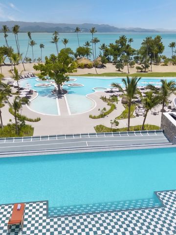 Infinity Pool mit Meerblick und Palmen im Hintergrund