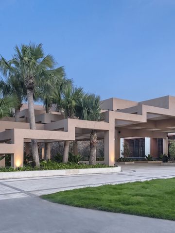 Moderne Hotelarchitektur mit Palmen und gepflegten Rasenflächen
