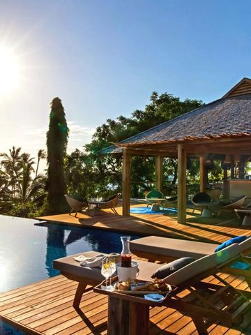 Sonnendeck mit Infinity-Pool und tropicaler Aussicht