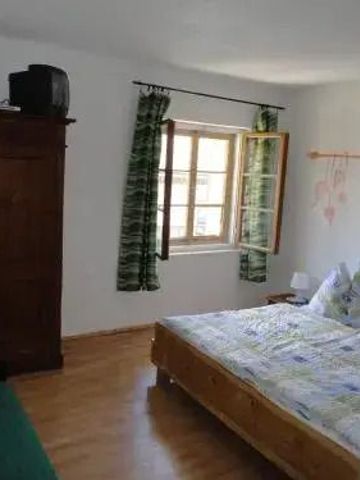 Helles Zimmer mit großem Fenster und rustikalen Möbeln