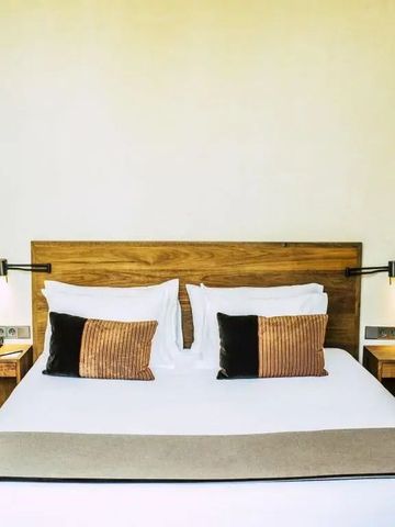 Komfortables Doppelbett mit eleganten Holzmöbeln in einem Hotelzimmer