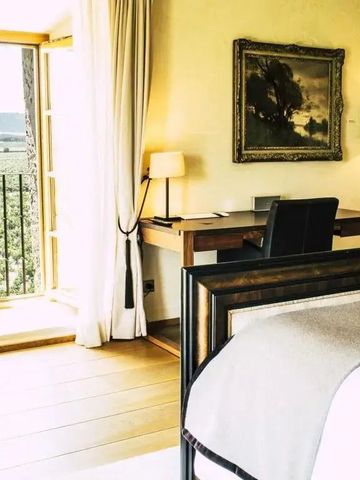 Helles Hotelzimmer mit Balkonblick auf die Landschaft, Schreibtisch und Kunstwerk