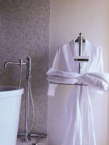 Elegante freistehende Badewanne mit Bademantel und Handtüchern.