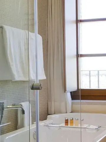 Modernes Badezimmer mit Badewanne und großen Fenstern.