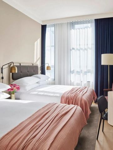 Helles Hotelzimmer mit zwei Einzelbetten und großen Fenstern