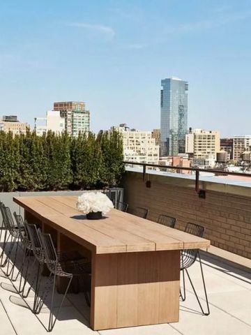 Rooftop-Terrasse mit langer Holztafel und Stadtblick über New York