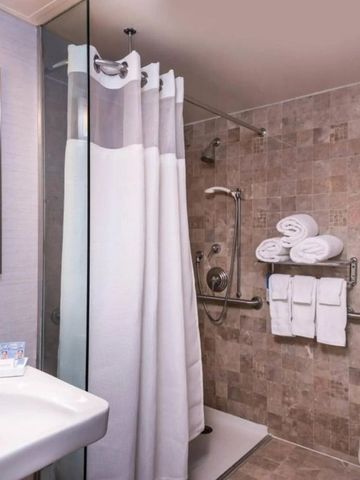 Helles Hotelbad mit begehbarer Dusche und modernen Armaturen