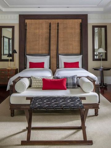 Luxuriöses Gästezimmer mit zwei Einzelbetten und roten Akzenten