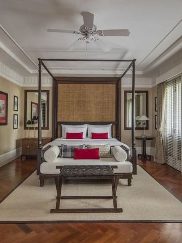 Großes Schlafzimmer mit Himmelbett und feinem Holzboden