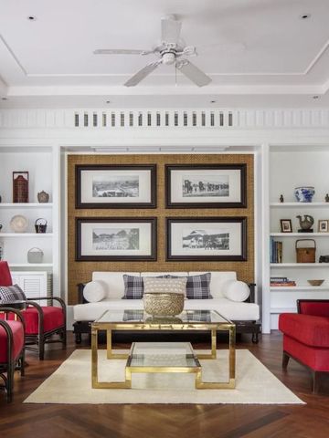 Stilvoll eingerichtete Lounge mit roten Sesseln und Bücherregalen