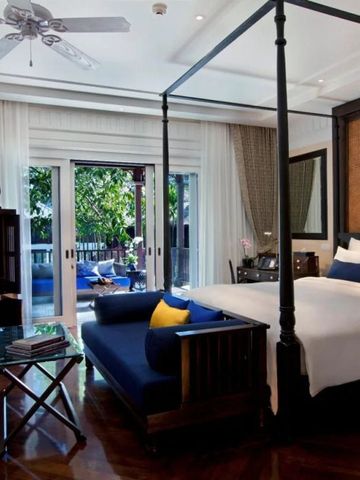 Elegantes Schlafzimmer mit Himmelbett und Terrasse mit Blick auf den grünen Garten