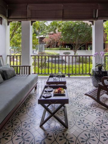 Entspannte Terrasse mit Blick auf den grünen Garten und bequemen Sitzgelegenheiten