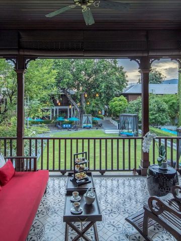 Einladende Terrasse mit rotem Sofa und Blick auf gepflegten Garten
