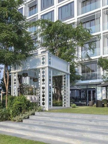 Moderne Hotelarchitektur mit begrüntem Eingangsbereich und elegantem Außensitzplatz