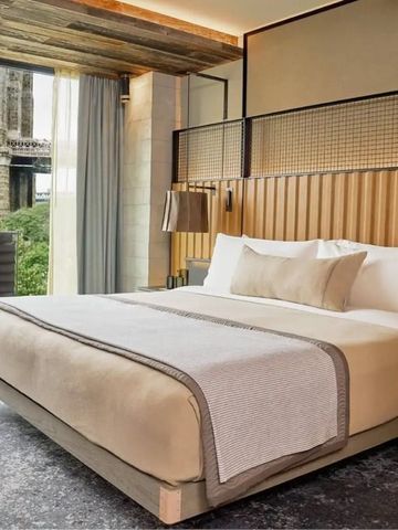 Einladendes Hotelzimmer mit großem Bett und Blick auf die Brooklyn Bridge