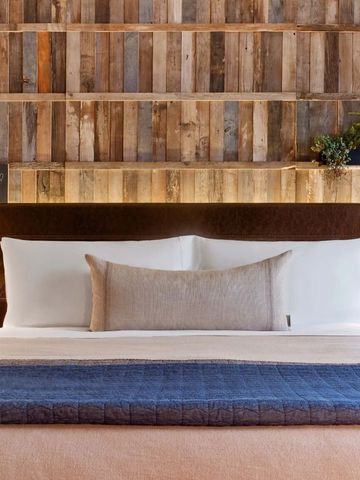 Gemütliches Bett mit Holzverkleidung und Pflanzen im 1 Hotel Central Park