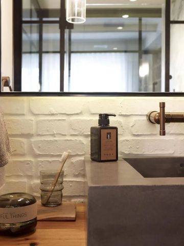 Waschbeckenbereich mit stilvollen Armaturen und Spiegel im Hotelbad.