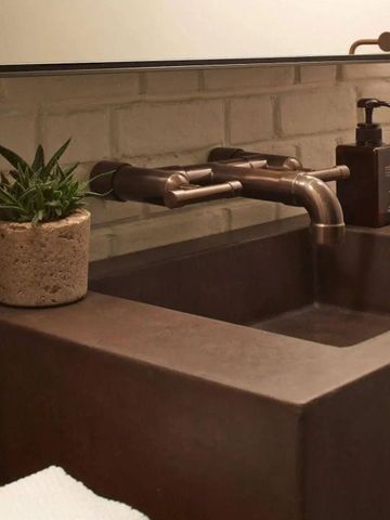 Stilvoll gestaltetes Badezimmer mit einzigartigem Waschbecken und Pflanzendekor.