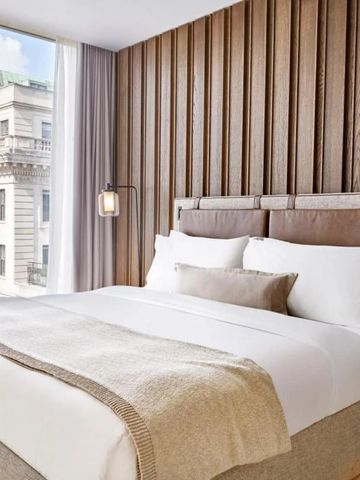 Luxuriöses Hotelzimmer mit großer Fensterfront und edler Holzverkleidung