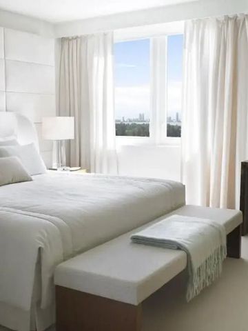 Helles Schlafzimmer mit großem Bett und Blick auf die Stadt