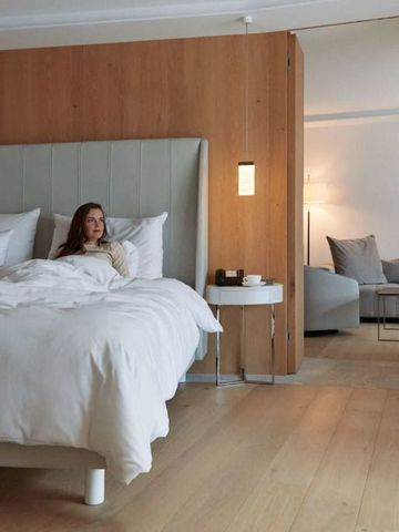 Zimmer mit großem Bett und Sitzbereich in warmen Holztönen