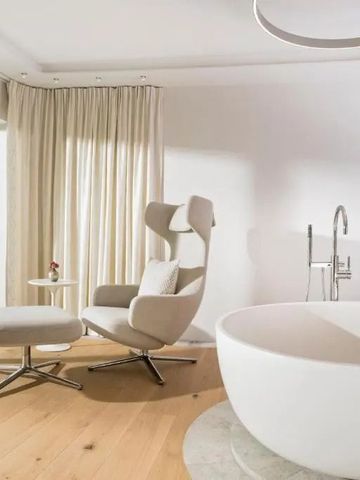 Helles Badezimmer mit großzügiger Badewanne und Leseecke