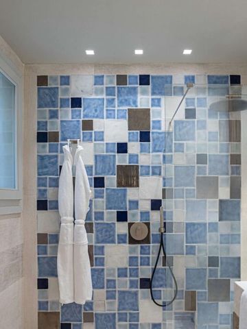 Luxuriöses Badezimmer mit Mosaikfliesen und Regendusche