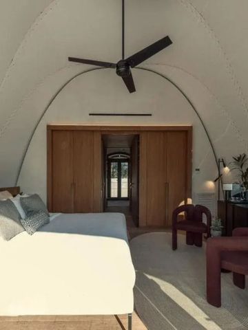 Geräumiges Zimmer mit Doppelbett und minimalistischer Einrichtung