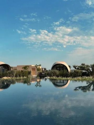 Moderner Infinity-Pool mit eleganten Bungalows und blauem Himmel im Hintergrund