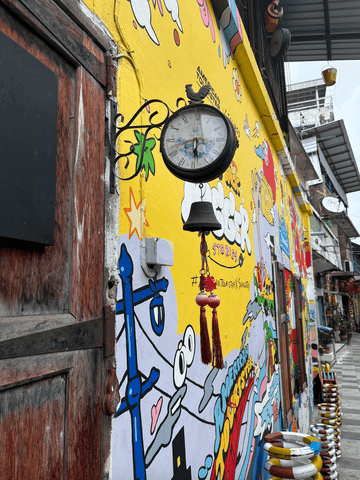 Während der Fototour begegnet man beeindruckender Streetart – darunter auch eine alte Uhr, die charmant in die urbane Kunstszene Bangkoks eingebettet ist.