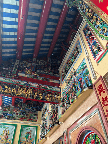 Der Innenraum des chinesischen Tempels beeindruckt mit leuchtenden Farben, kunstvollen Verzierungen und detailreichen Wandmalereien – ein Ort voller Spiritualität und lebendiger Tradition.