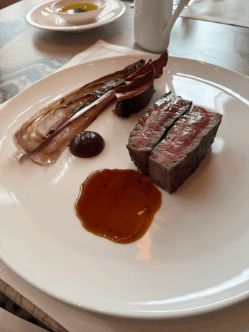 Mittagsgenuss auf höchstem Niveau: Im Four Seasons Bangkok wird zartes Steak perfekt gegrillt und von saisonalem Gemüse begleitet – ein kulinarisches Highlight in stilvollem Ambiente.