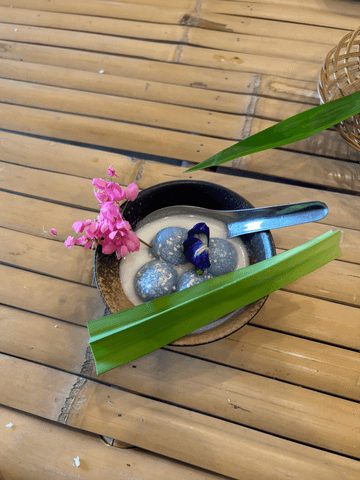 Zartblaue Reiskugeln schwimmen in einer cremigen Kokossauce – ein traditionell thailändisches Dessert, das nicht nur optisch begeistert.