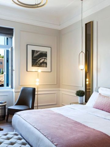 Helles und gemütliches Schlafzimmer mit Fenster und Kunstwerken