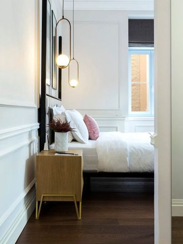 Gemütliches Schlafzimmer mit modernen Leuchten und Nachttisch