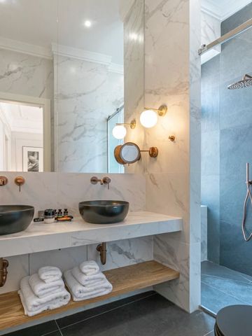 Luxuriöses Badezimmer mit Doppelwaschbecken und großer Duschkabine