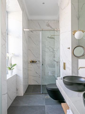 Helles Badezimmer mit Glasduschkabine und eleganten Armaturen