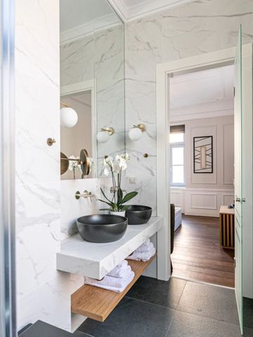 Modernes Badezimmer mit Doppelwaschbecken und Blick ins Schlafzimmer