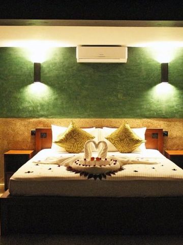 Stilvolles Schlafzimmer mit grüner Akzentwand und romantischer Dekoration