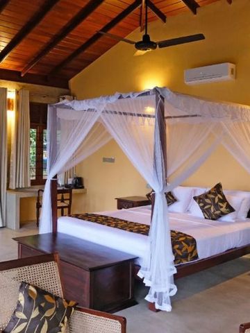 Luxuriöses Schlafzimmer mit Himmelbett und Holzbalkendecke