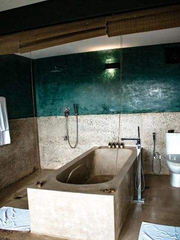 Geräumiges Badezimmer mit freistehender Badewanne und grüner Wand