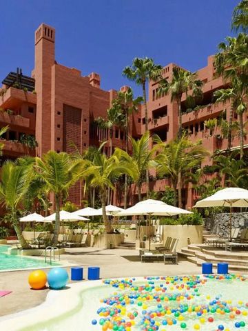 Tropischer Hotelpool mit Palmen, Sonnenliegen und farbigen Ballspielbereich