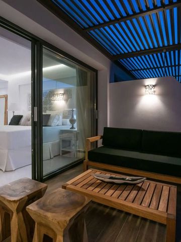 Moderne Terrasse mit gemütlicher Sitzgelegenheit und Blick ins Zimmer.