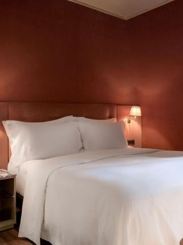 Elegantes Schlafzimmer mit beruhigenden Erdtönen und luxuriösem Bett.