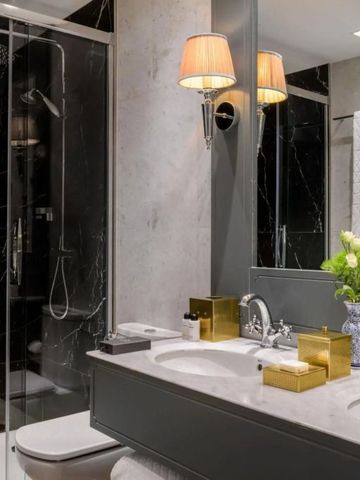 Luxuriöses Badezimmer mit Marmordetails und eleganter Beleuchtung.
