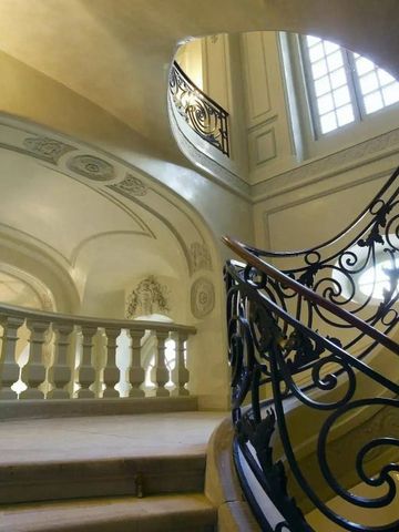 Elegante geschwungene Treppe mit kunstvollen Geländern und natürlichen Lichtakzenten