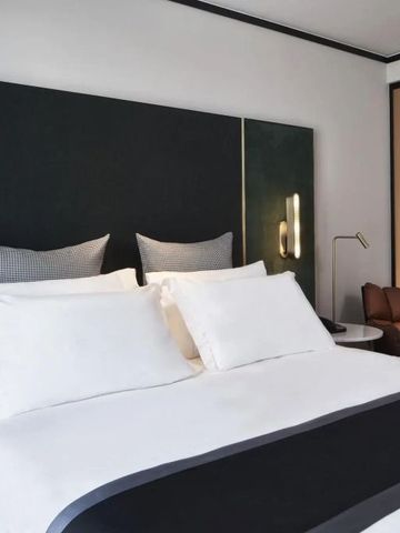 Komfortables Hotelzimmer mit stilvollem Bett und sanfter Beleuchtung